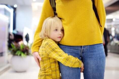 Un enfant timide collé à sa maman.