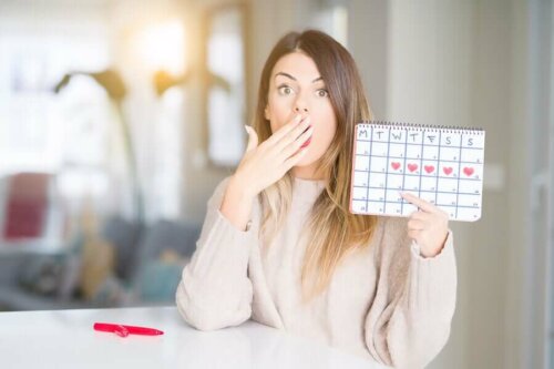 Une femme tenant un calendrier pour savoir quand est-ce qu'elle va ovuler.