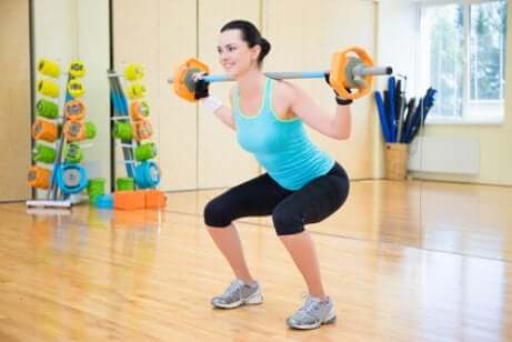 Une femme qui fait des squats avec des poids.