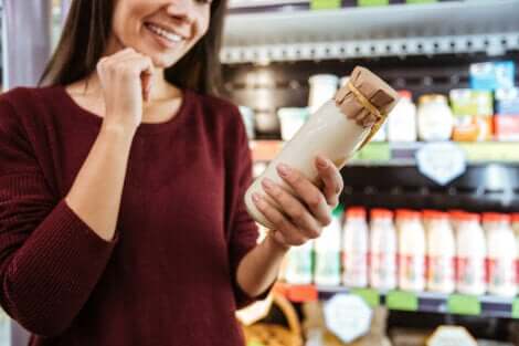 Une femme qui choisit un yaourt au supermarché.