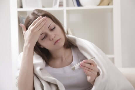Une femme malade qui prend sa température.
