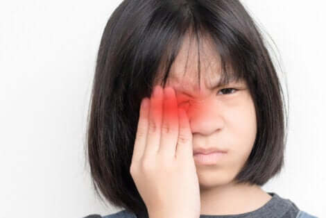 Une jeune fille avec un oeil douloureux et enflammé. 