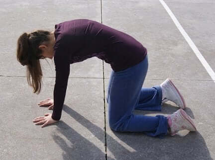Une femme réalise un exercice sur le sol.