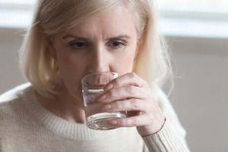 Une femme qui boit un verre d'eau.