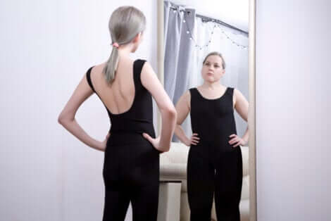 Une jeune femme devant un miroir avec une image erronée.