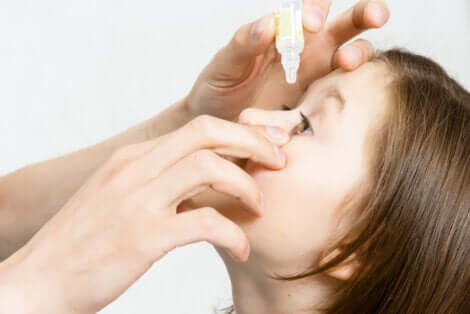 Application de gouttes oculaires chez une jeune fille.