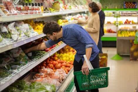 Un homme achetant des légumes au supermarché.