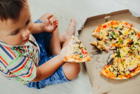 Un enfant qui mange de la nourriture rapide.