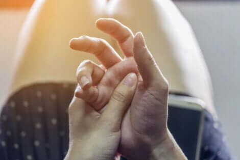 Une personne qui se touche les mains.