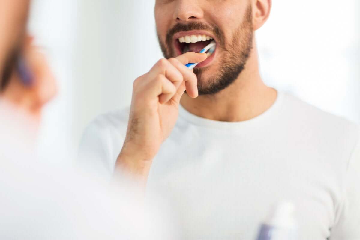 Un homme se brosse les dents.