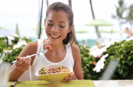 Une jeune femme qui mange une salade avec du thon. 