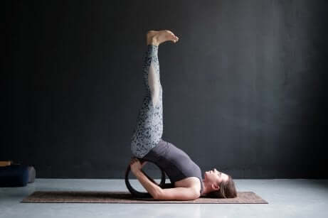 Une femme dans la posture de yoga des jambes contre le mur. 