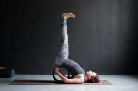 Une femme dans la posture de yoga des jambes contre le mur.