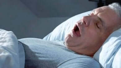 Un homme qui dort la bouche ouverte.