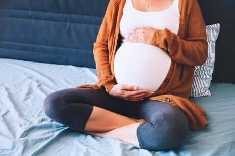 Une femme enceinte assise dans son lit pour le cerveau de son futur bébé.