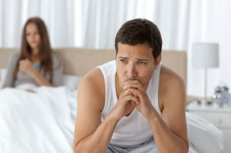 Un jeune homme pensif sur son lit avec sa partenaire.