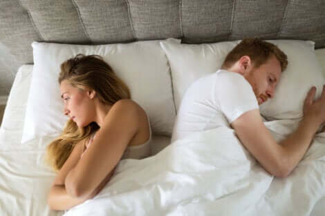 Un couple qui se tourne le dos dans un lit.