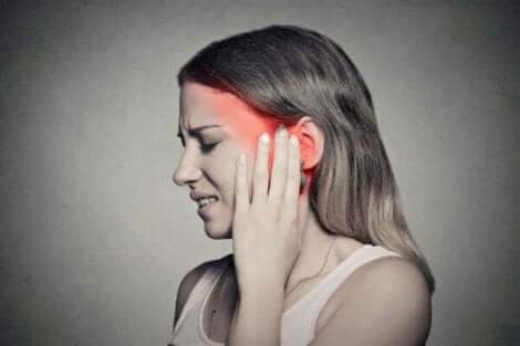 Une femme qui ressent une douleur à l'oreille.