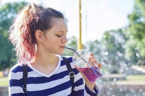 Une femme boit un liquide violet.