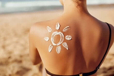Soleil dessiné avec de l'écran solaire sur le dos d'une femme. 