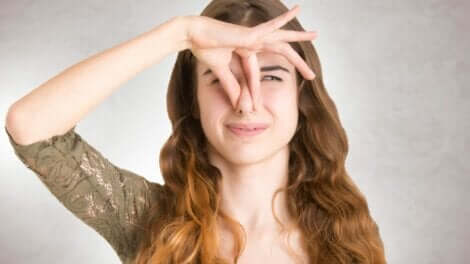 Une femme qui se bouche le nez.