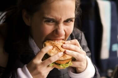 Une femme qui mange un hamburger.