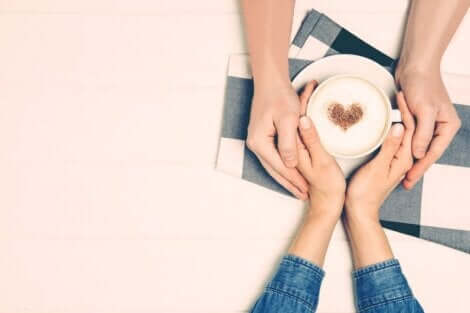 Les mains d'un couple autour d'une tasse de café. 