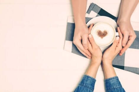 Les mains d'un couple autour d'une tasse de café.
