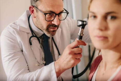 Un médecin qui examine l'oreille d'une femme.