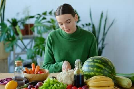 Une femme qui cuisine des fruits et des légumes.