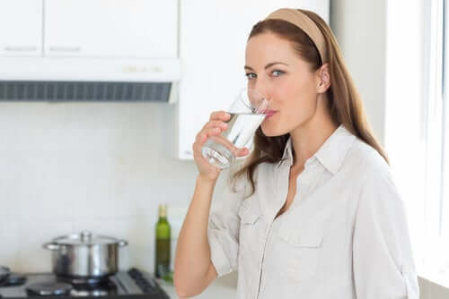 Une femme qui boit un verre d'eau. 