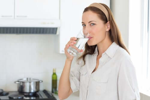 Une femme qui boit un verre d'eau.