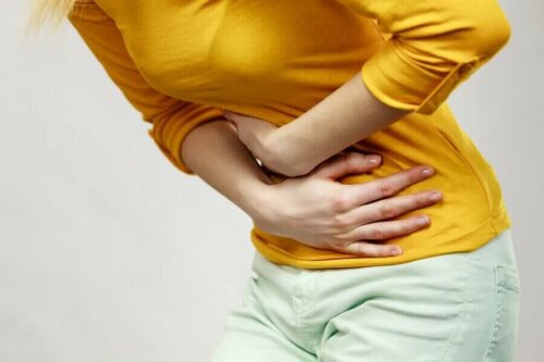 Une femme se tenant l'abdomen.
