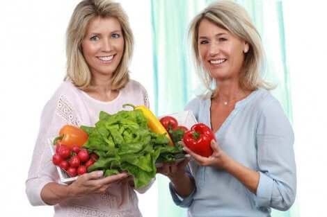 Deux femmes avec des légumes dans les mains.