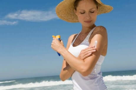 Une femme qui applique une protection solaire.