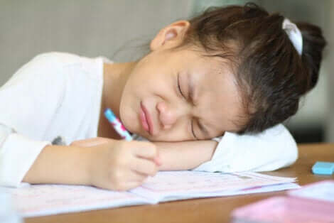 Une jeune fille fâchée devant ses devoirs.