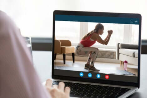 Un écran d'ordinateur avec une femme qui fait des squats. 