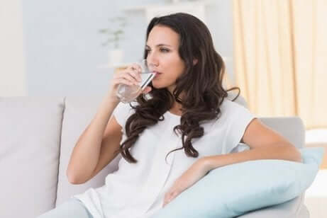Une femme qui boit un verre d'eau.
