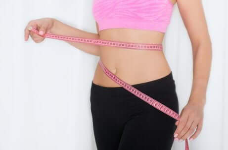 Une femme qui mesure sa taille.