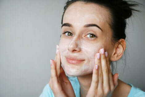 Une femme qui se met de la crème sur le visage avec des peptides.