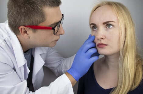 Un médecin qui ausculte les yeux d'une jeune femme. 