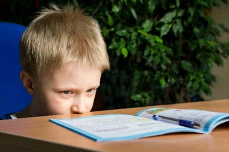 Un jeune garçon en difficulté avec ses devoirs scolaires. 