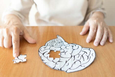 Une personne âgée qui fait un puzzle en forme de cerveau. 