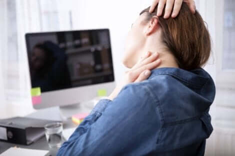 Une femme qui s'étire la nuque en travaillant devant l'ordinateur.