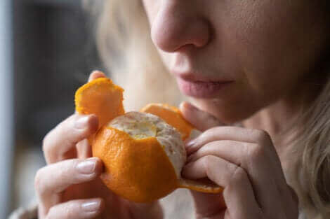 Une femme sentant une mandarine.