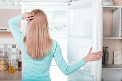 Une femme devant son congélateur.