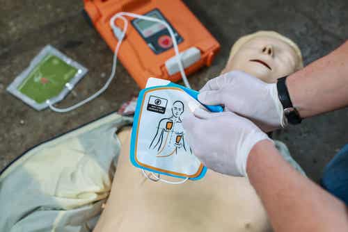 Un défibrillateur posé sur un mannequin.