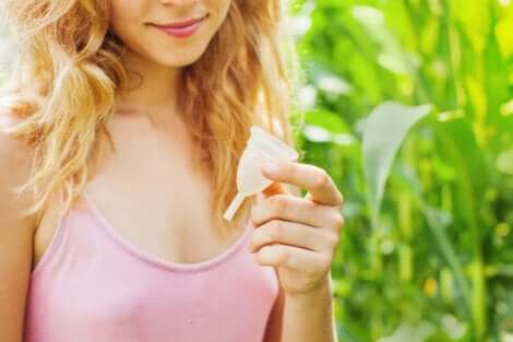 Une femme avec une coupe menstruelle dans la main.
