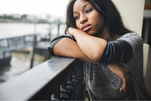 Une femme triste à son balcon.