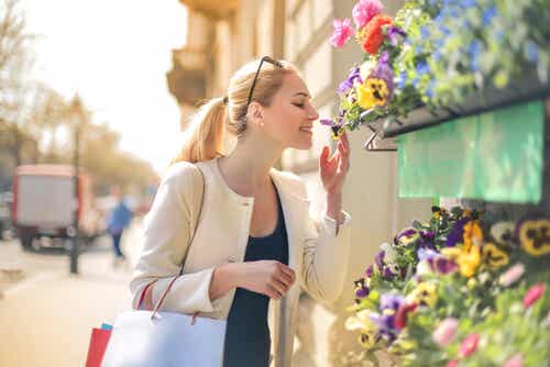 Femme qui renifle des fleurs.